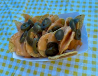 nachos with cheese and jalapenos on a checkered tablecloth